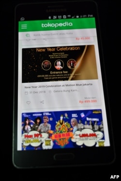 This picture taken in Jakarta on Dec. 12, 2018 shows a website of Tokopedia on a mobile phone selling tickets.
