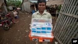 This Aug. 29, 2009 photo shows village malaria worker Phoun Sokha, 47, showing his malaria medicine kit at O'treng village on the outskirts of Pailin, Cambodia. 