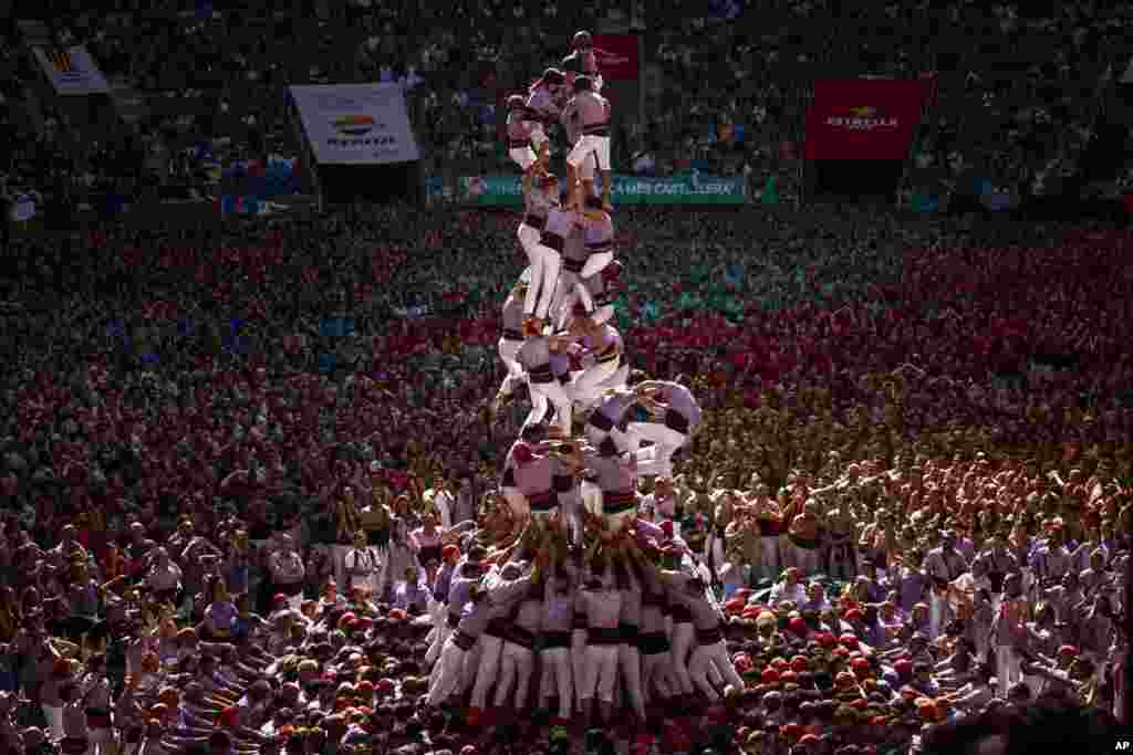 Members of "Colla Jove de Tarragona" fall before completing a "Castell" or human tower, during the 29th Human Tower Competition in Tarragona, Spain.