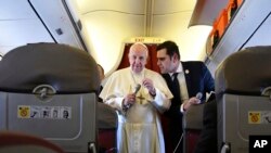 Pope Francis, flanked by interim director of Holy See Press Office, Alessandro Gisotti, speaks to reporters on board the flight back to Rome from a two-day trip to Morocco, Sunday, March 31, 2019. 