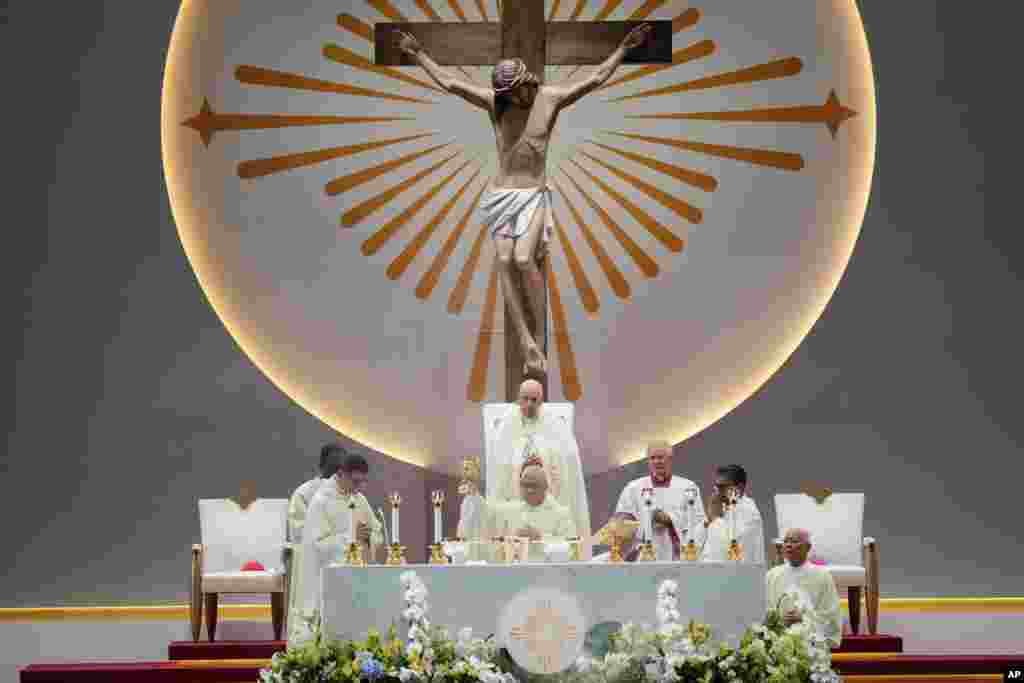 Pope Francis, standing, presides over a Holy Mass at the SportsHub National Stadium in Singapore.