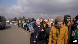 Watu wanaokimbia kutoka Ukraine wakipanga foleni ya kupanda basi kwenye kivuko cha mpaka huko Medyka, Poland, Ijumaa, Machi 4, 2022. Zaidi ya watu milioni 1 wameikimbia Ukraine kufuatia uvamizi wa Russia. (Picha ya AP/Markus Schreiber)
