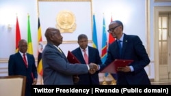 Rais Paul Kagame wa Rwanda na Rais Yoeri Museveni wa Uganda, wakipeana mikono baadayakutia saini Mkataba wa Rwanda na Uganda.