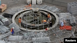 FILE - Workers arrange a steel structure at a construction site in Hanoi, Vietnam, Dec. 27, 2018. 