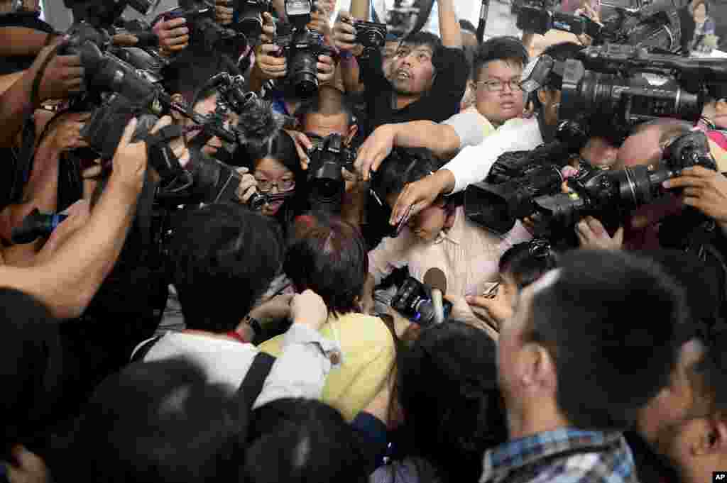 Members of the media surround a relative of a passenger on board Malaysia Airlines MH17 that went down in war-torn Ukraine, at Kuala Lumpur International Airport in Sepang, Malaysia, July 18, 2014.