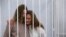 Yekaterina Andreeva and Darya Chultsova, journalists working for the Polish television channel Belsat, embrace inside a defendants' cage during a court hearing in Minsk, Belarus, Feb. 9, 2021.