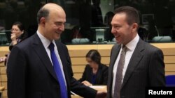 France's Finance Minister Pierre Moscovici talks with Greece's Finance Minister Yannis Stournaras (R) during a Eurogroup meeting in Brussels, December 13, 2012. 
