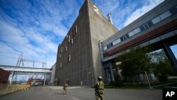 ARCHIVO: Soldados rusos custodian un edificio de la central nuclear de Zaporiyia, en territorio controlado por el ejército ruso, en el sureste de Ucrania, el 1 de mayo de 2022.