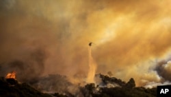 直升機在洛杉磯太平洋帕利塞茲社區向正在蔓延的大火噴水。
