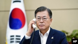FILE - South Korean President Moon Jae-in talks on the phone with Japanese Prime Minister Yoshihide Suga at the presidential Blue House in Seoul, South Korea, Sept. 24, 2020. 