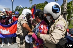 រូប​ឯកសារ៖ កងសន្ដិសុខ​រឹបអូស​ឧបករណ៍​បំពង​សំឡេង​ពី​បាតុករ​ម្នាក់ ក្នុង​អំឡុងពេល​នៃ​ការ​ធ្វើ​បាតុកម្ម​មួយ​ដើម្បី​ប្រារព្ធ​ខួប​ទី​២៩ នៃ​កិច្ចព្រមព្រៀង​សន្ដិភាព​ទីក្រុង​ប៉ារីស​នៅ​មុខ​ស្ថានទូត​សហរដ្ឋអាមេរិក រាជធានី​ភ្នំពេញ ​ថ្ងៃទី២៣ ខែតុលា ឆ្នាំ២០២០។