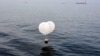 Sebuah balon yang membawa berbagai benda termasuk sampah, yang diyakini dikirim oleh Korea Utara, terlihat di laut lepas Incheon, Korea Selatan, 9 Juni 2024. (Foto: Yonhap via REUTERS)