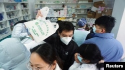 杭州一家藥店，人們排隊購買新冠病毒抗原檢測試劑盒。