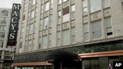 Una mujer usando una mascarilla pasa frente a una tienda Macy's en San Francisco, California, el 30 de marzo de 2020.