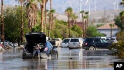 Čovek čeka da izvuku njegov auto iz mulja (Foto: AP/Mark J. Terrill)