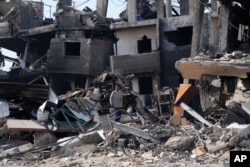 Seorang warga Palestina melihat kehancuran akibat pemboman Israel di kamp pengungsi Maghazi, Jalur Gaza tengah, 16 Februari 2024. (Foto: Adel Hana/AP Photo)