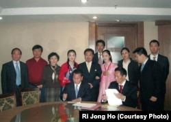 Ri Jong Ho, seated at left, seals a deal on North Korea’s oil exploration with a Hong Kong international oil company in November 2006.