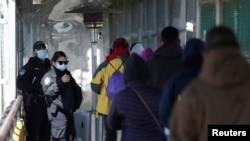 Un grupo de personas camina hacia Brownsville, Texas, EE.UU., en el puente fronterizo internacional Matamoros-Brownsville, visto desde Matamoros, México, el 19 de febrero de 2021.