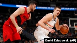 Nikola Jokić u duelu sa Jusufom Nurkićem (Foto: AP/David Zalubowski)
