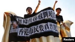 Pro-democracy activists protest on the Golden Bauhinia Square, a gift from China at the 1997 handover, during a protest a day before Chinese President Xi Jinping is due to arrive. 