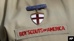 FILE - A detail of a Boy Scout uniform in front of the Boy Scouts of America headquarters in Irving, Texas, Feb. 4, 2013.