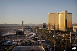 The Mandalay Bay resort and casino, right, overlooks an outdoor festival grounds across the street, left, Tuesday, Oct. 3, 2017, in Las Vegas. Authorities said Stephen Craig Paddock broke the windows on the casino and began firing with a cache of weapons,