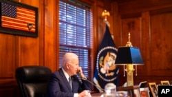 In this image provided by the White House, President Joe Biden speaks with Russian President Vladimir Putin on the phone from his private residence in Wilmington, Del., Dec. 30, 2021. (Adam Schultz/The White House via AP)
