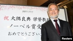 Yoshinori Ohsumi, a professor of Tokyo Institute of Technology smiles in front of a celebration message board after he won the Nobel medicine prize in Yokohama, Japan, October 3, 2016 in this photo released by Kyodo. 