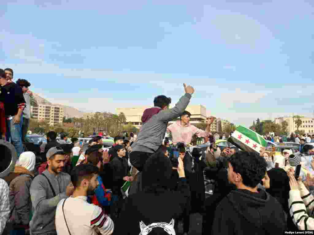 Başkent Şam'ın merkezindeki meydanlarda ve ana caddelerde insanlar gruplar halinde Esat&rsquo;ın devrilmesini kutluyor