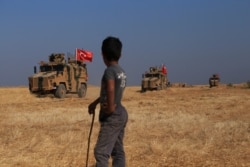 A Turkish armored vehicles patrol joins a joint ground patrol with American forces in the so-called "safe zone" on the Syrian side of the border with Turkey, Oct.4, 2019.