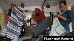 Employees of the Sammy Ethiopia hand made garments, hand-woven textiles and basketry factory package scarfs for export to U.S. clients, at the factory in Addis Ababa, Ethiopia, October 14, 2021. (REUTERS/Tiksa Negeri)