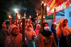 Anak-anak Muslim membawa obor di sekitar lingkungan selama parade untuk merayakan Idul Fitri, menandai akhir bulan suci Ramadhan, di tengah pandemi COVID-19 di Jakarta, 12 Mei 2021. (Foto: REUTERS/Willy Kurniawan)