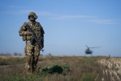 FILE - A Ukrainian serviceman secures an area in a Kyiv-controlled part of Donetsk region, eastern Ukraine, Oct. 14, 2019.