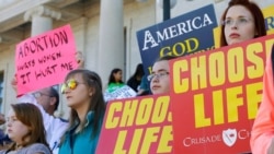 FILE - People hold signs at an anti-abortion rally at the Arkansas state Capitol.