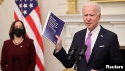Presiden AS Joe Biden, disaksikan Wapres Kamala Harris, menjelaskan rencana pemerintahannya untuk membendung pandemi virus corona, di Gedung Putih Kamis (21/1). 