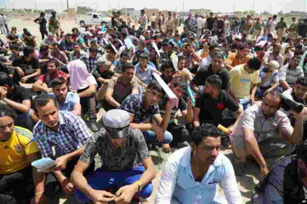 "Iroq va Shom islomiy davlati" jangarilariga qarshi kurashish uchun ko'ngilli bo'lib armiyaga qo'shilish istagida harbiy markaz yoniga yig'ilgan iroqliklar, 14-iyun, 2014-yil.