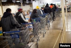 FILE - Clients wait in line to shop for food at the St. Vincent de Paul food pantry, Indianapolis, Indiana.