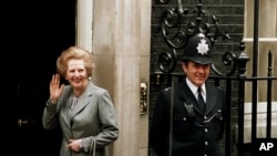 FILE - In this May 11, 1987 file photo, Britain's Prime Minister Margaret Thatcher waves to members of the media on returning to No. 10 Downing Street from Buckingham Palace after a visit with Queen Elizabeth II.