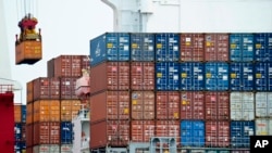 FILE - A container is loaded onto a cargo ship at the Tianjin port in China. The United States has formally told the World Trade Organization (WTO) that it opposes granting China market economy status, a position that if upheld would allow Washington to m