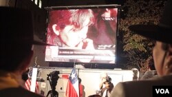 Con una mano en el corazón y la otra izando la bandera, algunos chilenos no pudieron contener las lágrimas al cantar el himno nacional.