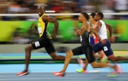 Jamaican sprinter Usain Bolt (in the lead) looks at the camera as he and other runners compete at the 2016 Olympics in Rio de Janeiro, Brazil. (Reuters Photo: Kai Pfaffenbach)