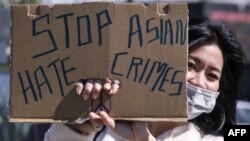 一名示威者在洛杉磯中國城附近手舉標語牌參加反對針對亞裔暴力犯罪的活動。（2021年2月20日）
