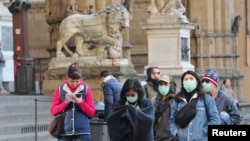 Un grupo de personas con mascarillas protectoras camina por la ciudad de Florencia, en el norte de Italia, el 7 de marzo de 2020. 