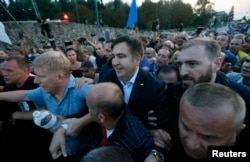 Former Georgian President Mikheil Saakashvili is surrounded by his supporters as he arrives at a checkpoint on the Ukrainian-Polish border in Shehyni, Ukraine, Sept. 10, 2017.