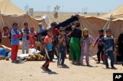 FILE - Internally displaced civilians from Fallujah flee their homes during fighting between Iraqi security forces and Islamic State group during a military operation to regain control of the city, outside Fallujah, 40 miles (65 kilometers) west of Baghdad, Iraq.