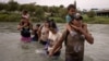 ARCHIVO: Orlando, un migrante de Ecuador, carga a su compatriota Peter, de cuatro años, mientras caminan por el río Grande desde México hasta Eagle Pass, Texas, EE. UU., el 6 de octubre de 2023.
