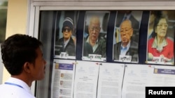 រូបឯកសារ៖ និស្សិតម្នាក់​មើល​រូបថតអតីតមេដឹកនាំ​ជាន់ខ្ពស់ខ្មែរក្រហម នៅ​លើ​ផ្ទាំង​ព័ត៌មាន​មួយ​ មុន​នឹង​ចូលរួម​ស្តាប់​សវនាការ​នៃ​អង្គជំនុំជម្រះវិសាមញ្ញក្នុង​តុលាការ​កម្ពុជា (ECCC) កាលពី​ថ្ងៃទី១៣ ខែធ្នូ ឆ្នាំ២០១១។ 