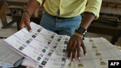 An Ivory Coast Electoral Commission official holds voting cards on Oct. 14, 2020, in Abidjan during distribution of voting cards ahead of the country's presidential election that will be held on Oct. 31, 2020. 