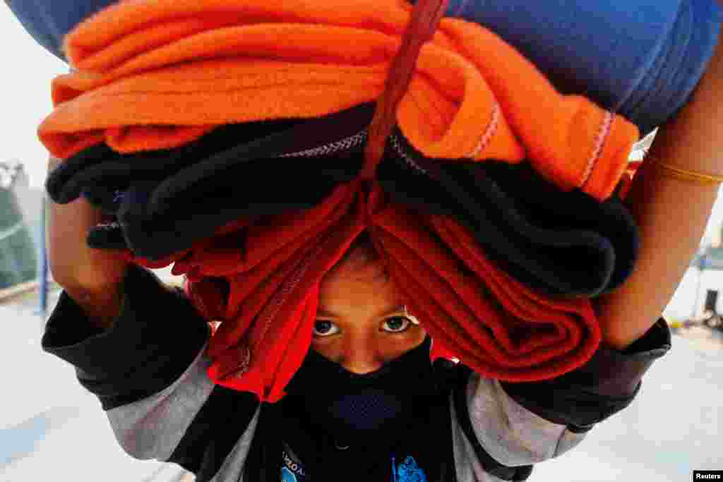 ក្មេងស្រីជនជាតិរ៉ូហ៊ីងយ៉ាម្នាក់លីសម្ភាៈ ខណៈត្រៀមខ្លួនធ្វើដំណើរតាមនាវាដើម្បីផ្លាស់ទីកន្លែងស្នាក់នៅលើកោះ Bhasan Char នៅប្រទេសបង់ក្លាដែស។ 