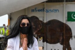 Pop singer Cher gestures in front of the crate of Kaavan upon his arrival in Cambodia at Siem Reap International Airport in Siem Reap on Nov. 30, 2020.